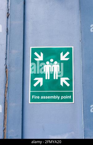 Panneau « Fire Assembly point » vert sur une porte d'usine Banque D'Images