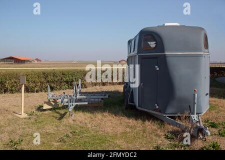 Une remorque de cheval avec des graphiques est prête à brancher et à aller . remorque de cheval d'argent sur le green Meadow . Remorque utilisée pour transporter un cheval adulte PAR tr Banque D'Images