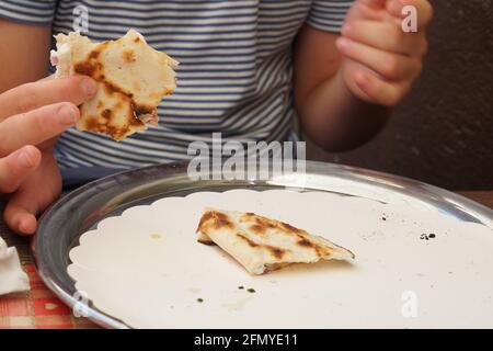 Garçon mangeant de la tarte flabée, en français, signifiant tarte cuite, plat typique en Alsace, France. Banque D'Images