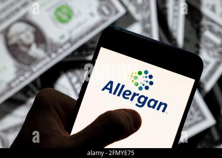 Chine. 23 avril 2021. Sur cette photo, le logo de la société pharmaceutique Allergan, domiciliée en Irlande, est affiché sur un smartphone avec une devise en USD (dollar des États-Unis) en arrière-plan. Crédit : SOPA Images Limited/Alamy Live News Banque D'Images