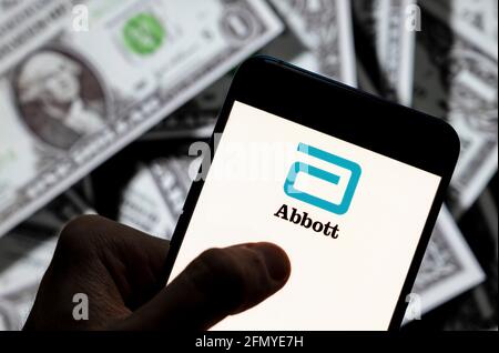 Chine. 23 avril 2021. Sur cette photo, le logo Abbott de l'entreprise américaine de dispositifs médicaux et de soins de santé est affiché sur un smartphone avec une devise en dollars américains (USD) en arrière-plan. Crédit : SOPA Images Limited/Alamy Live News Banque D'Images
