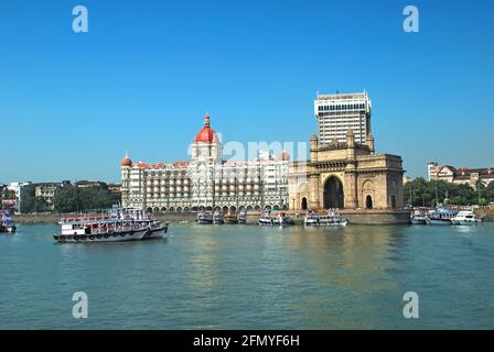 Vue panoramique sur le célèbre monument historique de Mumbai, la porte de l'Inde, vue depuis la mer d'Arabie, avec des bateaux d'excursion colorés en premier plan. C Banque D'Images