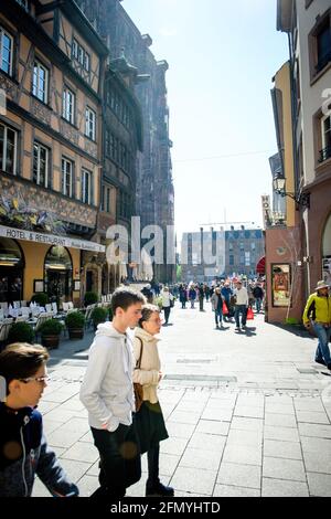 Groupe de jeunes touristes marchant devant la cathédrale notre-Dame À Strasbourg, près de la place de la Cathédrale Banque D'Images