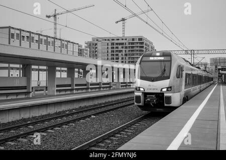 train en attente à la gare photo noir et blanc avec grues en arrière-plan Banque D'Images