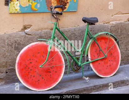 Florence, Italie - 20.06.2017: Vieux vélo vert avec roues faites pour ressembler à une tranche de pastèque, Florence, Italie. Banque D'Images