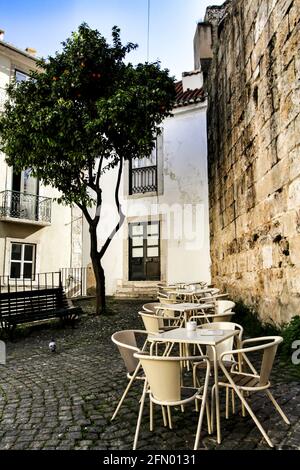 Terrasse de bar vide sur une rue étroite avec des façades majestueuses, des fenêtres et des balcons de la ville de Lisbonne au Portugal en une journée nuageux Banque D'Images