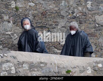 Penzance, Royaume-Uni. 12 mai 2021. Cornwall Royaume-Uni, St Michaels Mount, House of Dragon. Beaucoup de la fonte sans masques faciaux. Les acteurs reviennent de l'île en traversant un demi-kilomètre de mer ouverte enveloppée dans des capes étanches pour protéger les costumes coûteux. Une excursion en bateau agitée depuis le tournage sur l'île de St Michaels Mount jusqu'au mur du port de Marazion. 12 avril 2021. Crédit : Robert Taylor/Alay Live News Banque D'Images