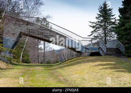 Un pont en porte-à-faux en béton d'époque s'étendant sur un chemin dans un parc. Banque D'Images