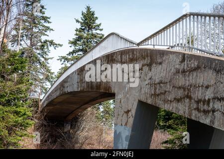 Un pont en porte-à-faux en béton d'époque s'étendant sur un chemin dans un parc. Banque D'Images