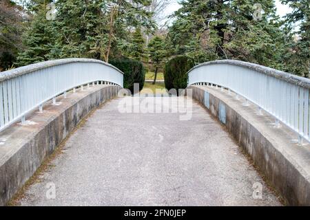 Un pont en porte-à-faux en béton d'époque s'étendant sur un chemin dans un parc. Banque D'Images