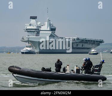 Une CÔTE du ministère de la police de la défense, avec des officiers armés à bord, surveille le départ du porte-avions HMS Prince of Wales de Portsmouth, au Royaume-Uni, le 30/4/21. Banque D'Images