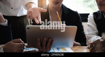 Un groupe de femmes d'affaires et de comptables examine les documents de données sur une tablette numérique en préparation à une enquête sur un cas de corruption Banque D'Images