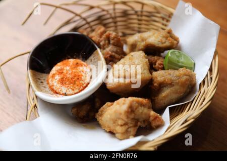 Poulet frit japonais Karaage avec citron et sauce sur bois arrière-plan Banque D'Images