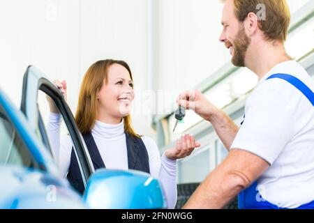 Cliente et mécanicien dans l'atelier automatique ou le mot avec voiture pour inspection de service Banque D'Images