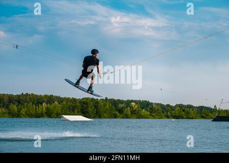 Homme pratiquant la technique de saut pendant la formation de wakeboard Banque D'Images