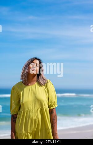 Femme debout à la plage avec ses yeux fermés Banque D'Images