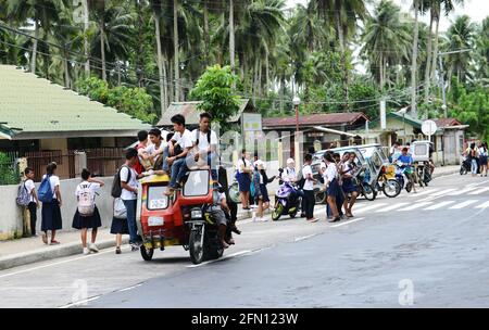 Élèves d'écoles à bord d'un tricycle dans la province de Sorsogon aux Philippines. Banque D'Images