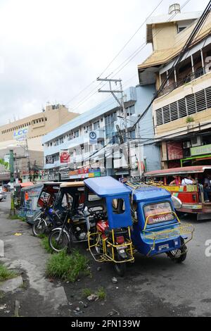 Tricycles dans le centre-ville de Legazpi. Banque D'Images