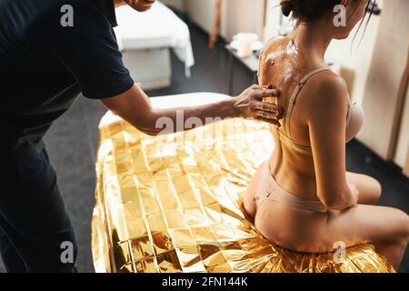 Charmante belle femme recevant un traitement au chocolat dans la clinique de beauté Banque D'Images