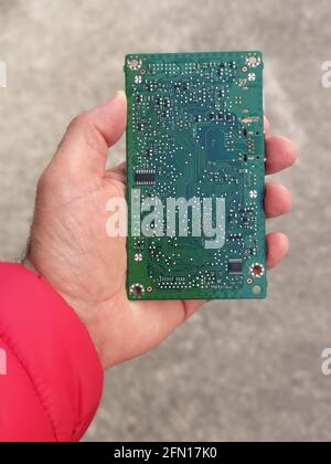 Vue de dessus d'une personne tenant un ordinateur imprimé en vert carte électronique Banque D'Images