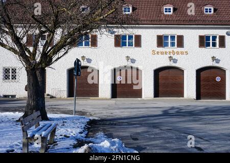 Caserne de pompiers, une maison de pompiers. Dans une petite ville au premier plan un banc et un grand arbre. Banque D'Images