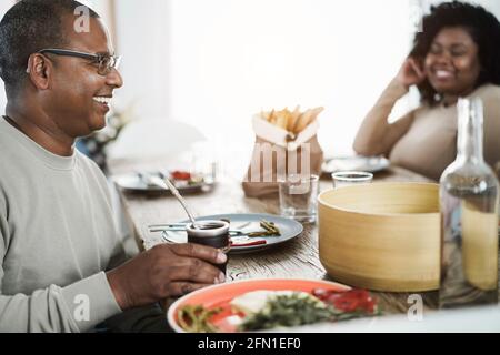 Heureux père africain buvant yerba mate pendant le déjeuner à la maison - accent principal sur le visage de l'homme Banque D'Images