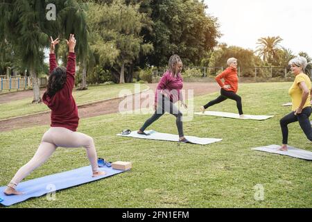 Des gens heureux qui font des cours de yoga au parc de la ville - Focus sur le visage de la femme africaine Banque D'Images