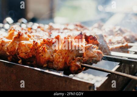 Cuisson de kebabs de porc marinés sur le gril. Kebabs de porc frits sur un feu ouvert. Saison de cuisson au gril. Banque D'Images