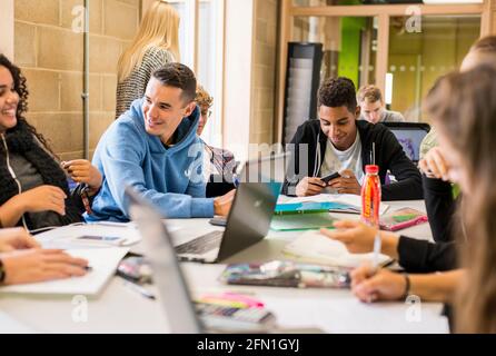 Les élèves multiculturels de la sixième forme, les jeunes dans l'éducation, les adolescents regardant l'ordinateur portable de la sixième forme, les étudiants travaillant à l'ordinateur portable Banque D'Images