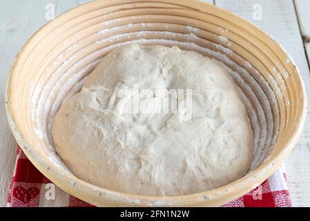 Faire du pain de levain maison - prouver la pâte dans un baneton de canne. Banque D'Images