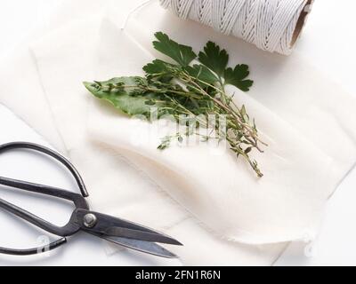 Les ingrédients traditionnels pour un bouquet garni mélange d'épices aux herbes, y compris une feuille de Laurier, parely et thym prêt à être enveloppé dans un tissu de fromage. Banque D'Images