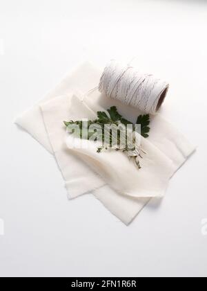 Les ingrédients traditionnels pour un bouquet garni mélange d'épices aux herbes, y compris une feuille de Laurier, parely et thym prêt à être enveloppé dans un tissu de fromage. Banque D'Images