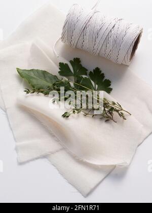 Les ingrédients traditionnels pour un bouquet garni mélange d'épices aux herbes, y compris une feuille de Laurier, parely et thym prêt à être enveloppé dans un tissu de fromage. Banque D'Images