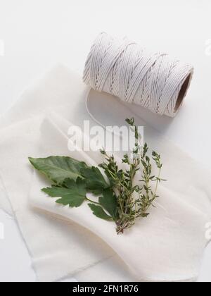 Les ingrédients traditionnels pour un bouquet garni mélange d'épices aux herbes, y compris une feuille de Laurier, parely et thym prêt à être enveloppé dans un tissu de fromage. Banque D'Images