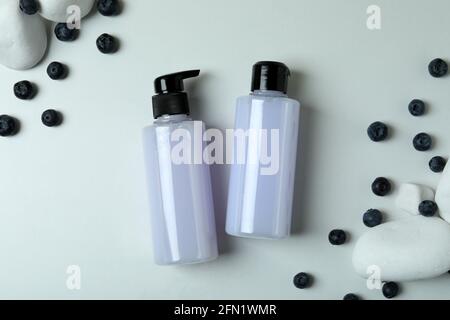 Gels douche, bleuets et pierres sur fond blanc Banque D'Images