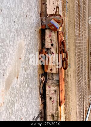 Chaîne cassée et cadenas rouillé sur la porte extérieure Banque D'Images