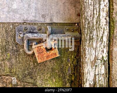 Ancien cadenas rouillé fixé à la vis de la porte en bois Banque D'Images