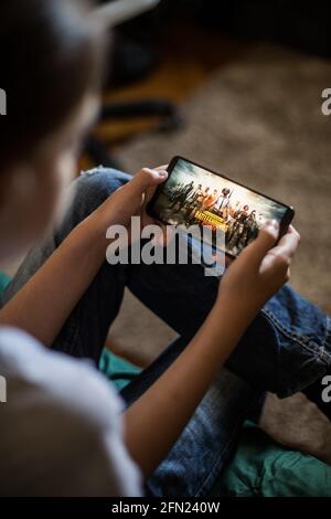 Bucarest, ROUMANIE - 10 mai 2021 : image éditoriale illustrative d'un enfant jouant à Battlefields sur un téléphone portable. Banque D'Images