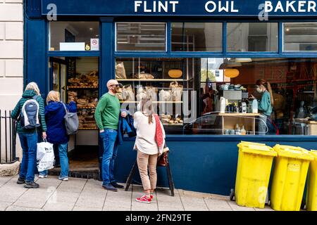 Les gens attendent devant UNE boulangerie pour acheter du pain et des pâtisseries, High Street, Lewes, East Sussex, Royaume-Uni. Banque D'Images