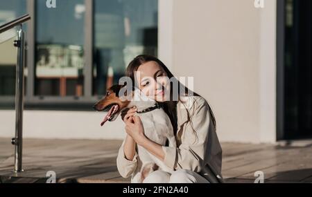 Bonne fille avec son chien dans la ville. Concept de mode de vie moderne pour les jeunes. Banque D'Images