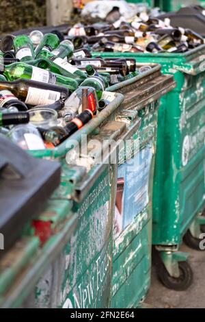 Bacs de recyclage des vieux métaux battus pleins de verre vert et Bouteilles brunes en attente de recyclage Royaume-Uni Banque D'Images