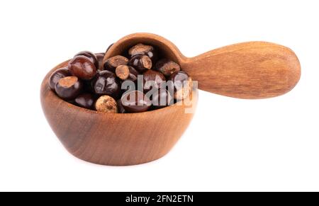 Graines de guarana dans un bol et une cuillère en bois, isolées sur fond blanc. Supplément alimentaire guarana, source de caféine pour boissons énergétiques. Banque D'Images