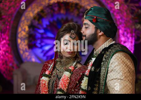 magnifique superbe mariée indienne et robe traditionnelle de marié posent sur leur cérémonie de mariage. Banque D'Images