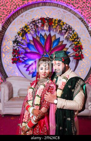 magnifique superbe mariée indienne et robe traditionnelle de marié posent sur leur cérémonie de mariage. Banque D'Images