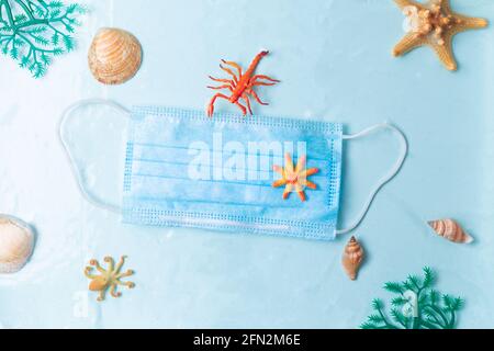 Pollution des déchets plastiques dans la mer depuis la pandémie du coronavirus COVID-19, concept de masque flottant sous la surface de l'eau Banque D'Images