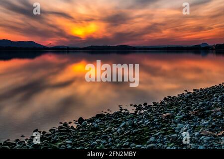 Coucher de soleil romantique sur les rives du lac de Constance avec de belles couleurs dans les gratte-ciel et des pierres sur la rive du lac Banque D'Images