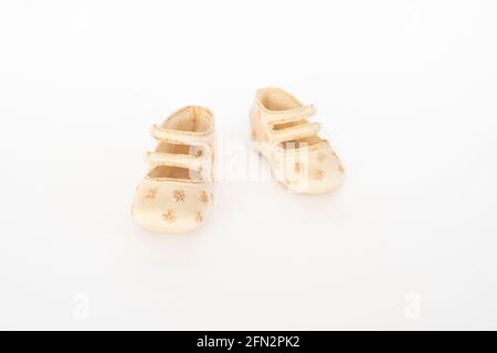 Décoration mini chaussures bébé sur fond blanc, mise au point sélective. Banque D'Images
