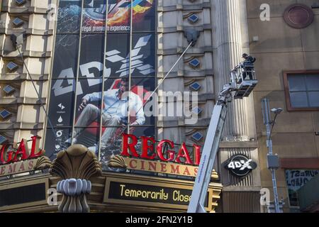 Ouvrier d'entretien de bâtiment dans un préparateur de cerisier travaillant sur le Regal Theatre sur la 42nd Street à 8th Avenue sur le côté ouest de Manhattan, quartier de Times Square. Banque D'Images