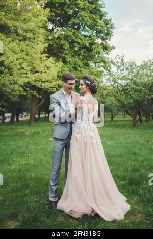 Tenue de mariage en couple avec pour toile de fond le parc, la mariée et le marié Banque D'Images