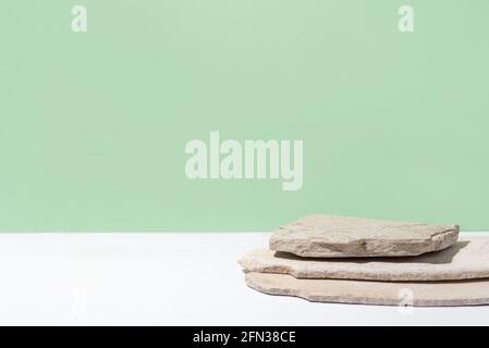 Arrière-plan pour les produits cosmétiques de couleur verte naturelle. Podium en pierre sur fond vert. Vue avant. Banque D'Images